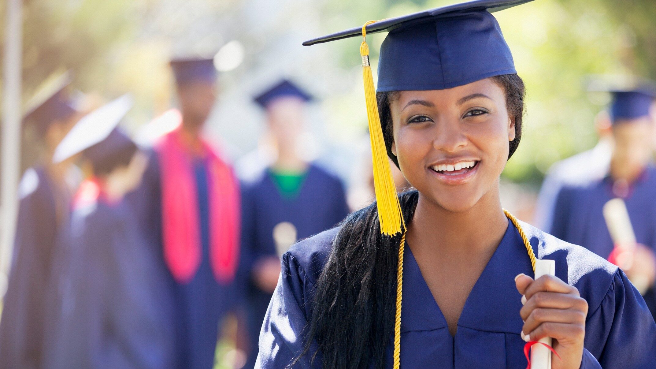 smiling female graduate wearing cap and gown